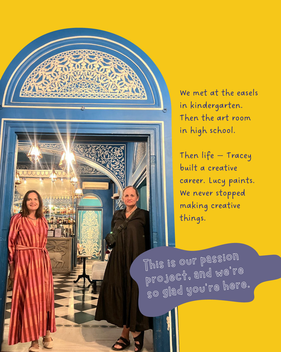 Colourstory founders Tracey and Lucy standing together in the ornate arched doorway of a beautiful blue and white Rajasthani interior, with intricate carved plasterwork, glittering chandeliers and decorative tiled floors behind them. Tracey wears a bold red and pink striped maxi dress, Lucy a flowing black dress. Text beside them reads "We met at the easels in kindergarten. Then the art room in high school. Then life — Tracey built a creative career. Lucy became a midwife. We never stopped making things.