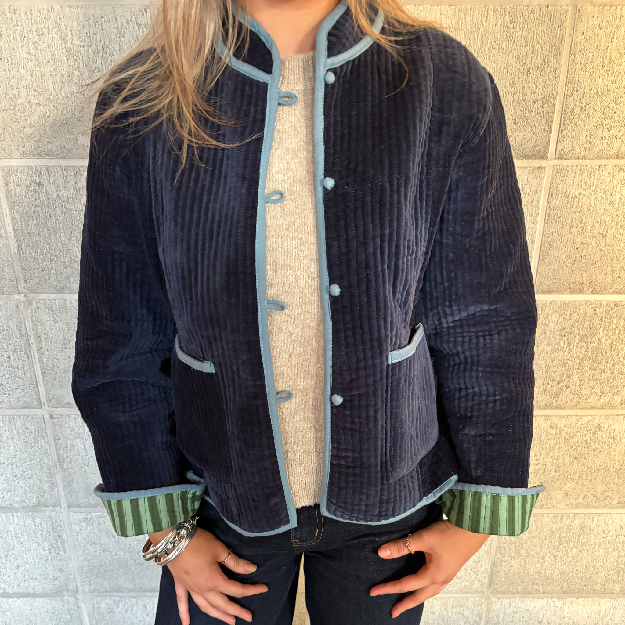 ColourStory model wearing navy velvet jacket with striped forest and sage green cuffs