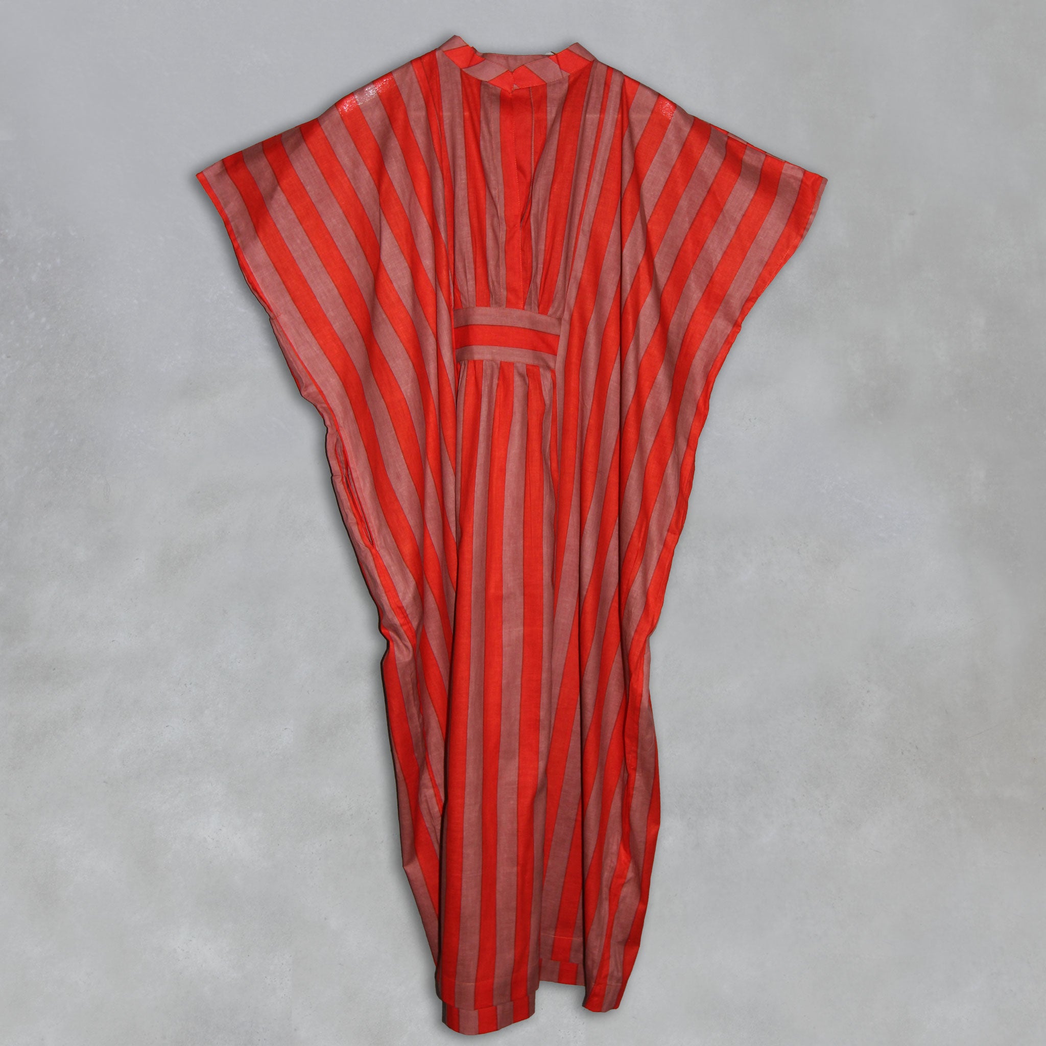 Orange and brown striped kaftan on a grey background