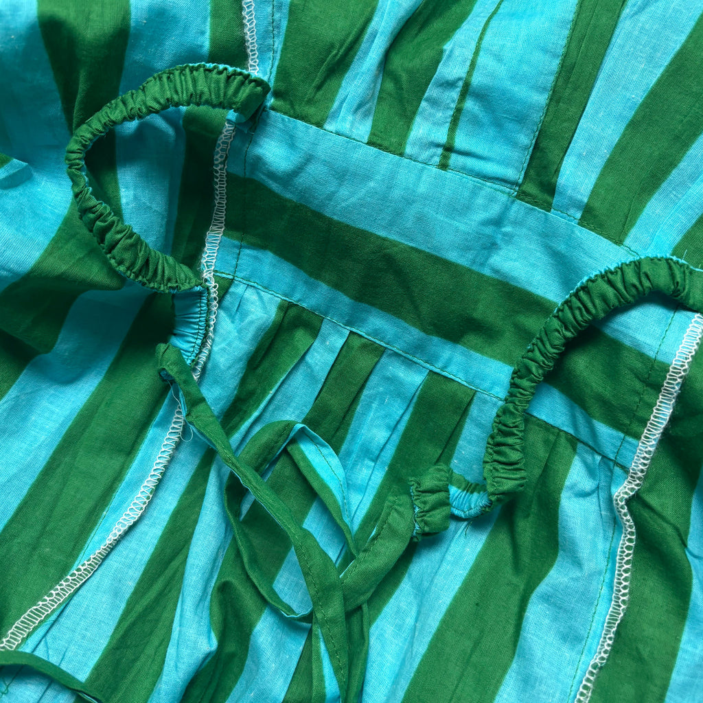 Close-up of green and blue striped kaftan fabric with waist ties to pull kaftan in around the waist