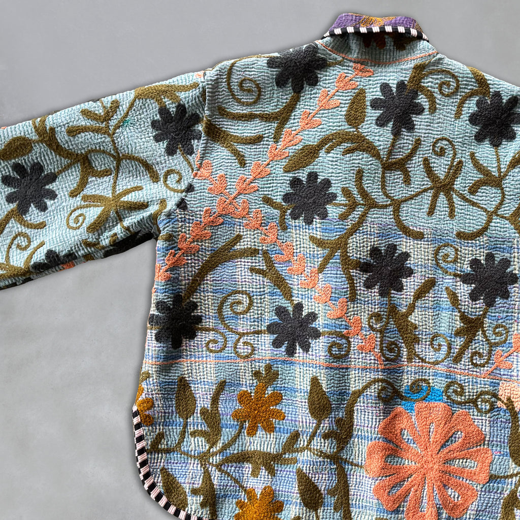 Embroidered fabric with floral patterns on a Kantha Jacket on a grey background