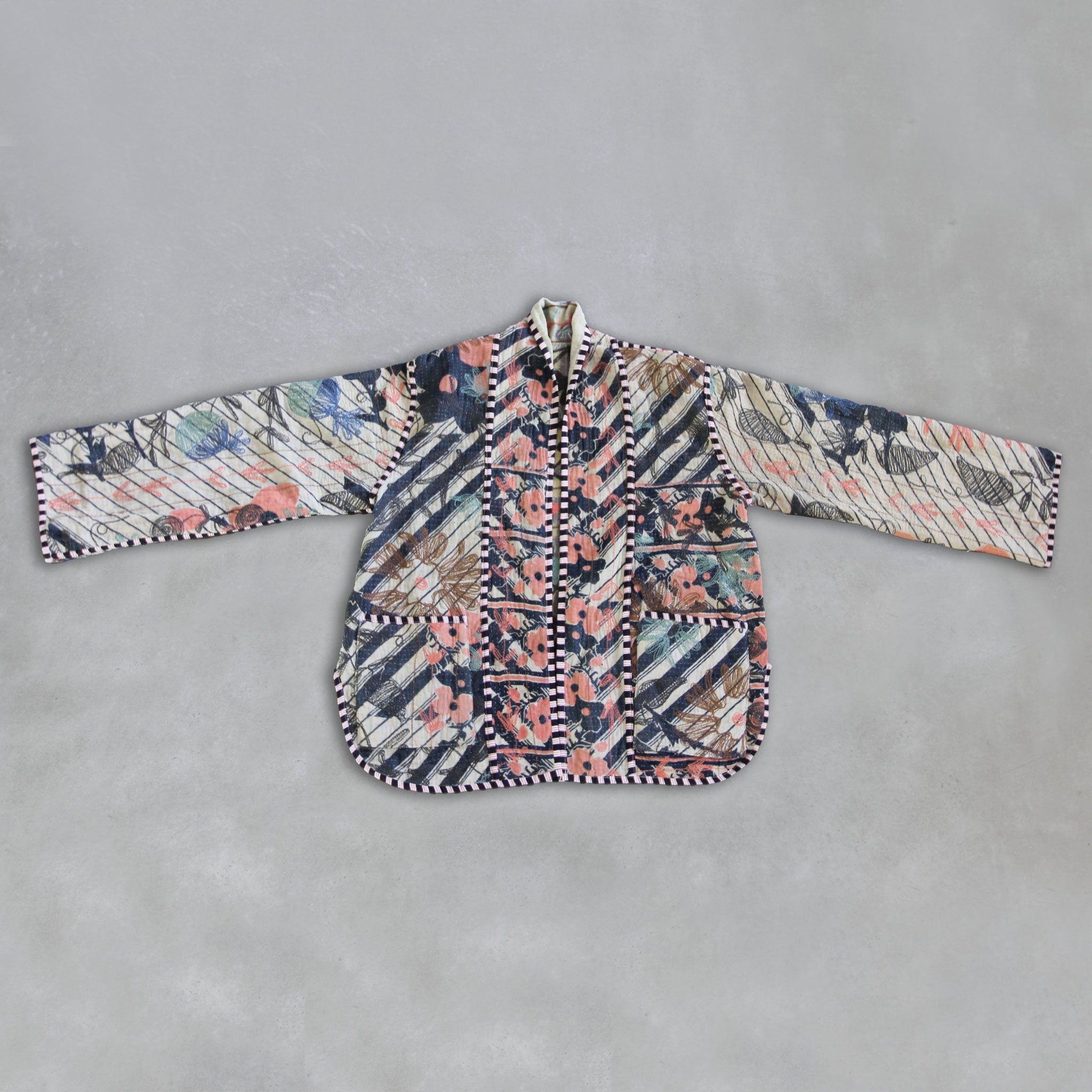 Colourful patterned Kantha jacket on a grey background