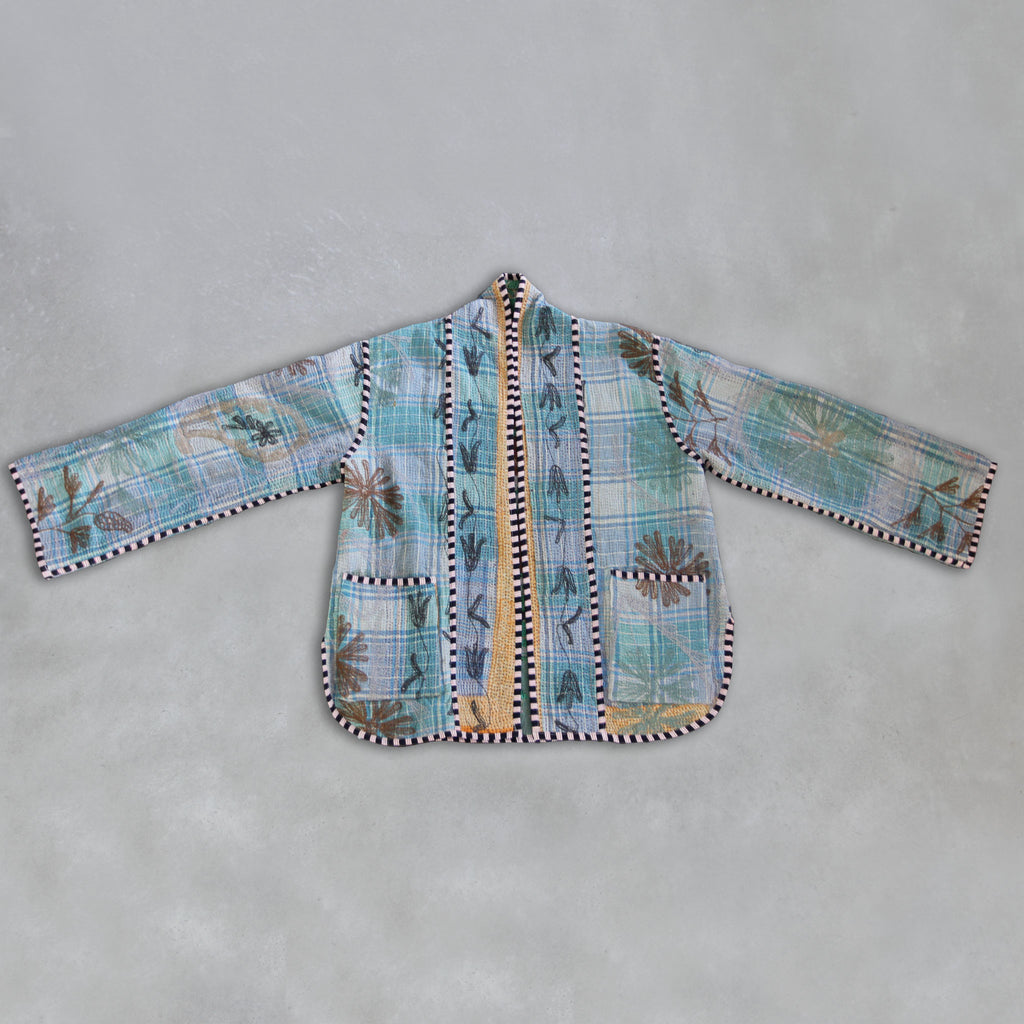Kantha jacket with floral patterns on a grey background.