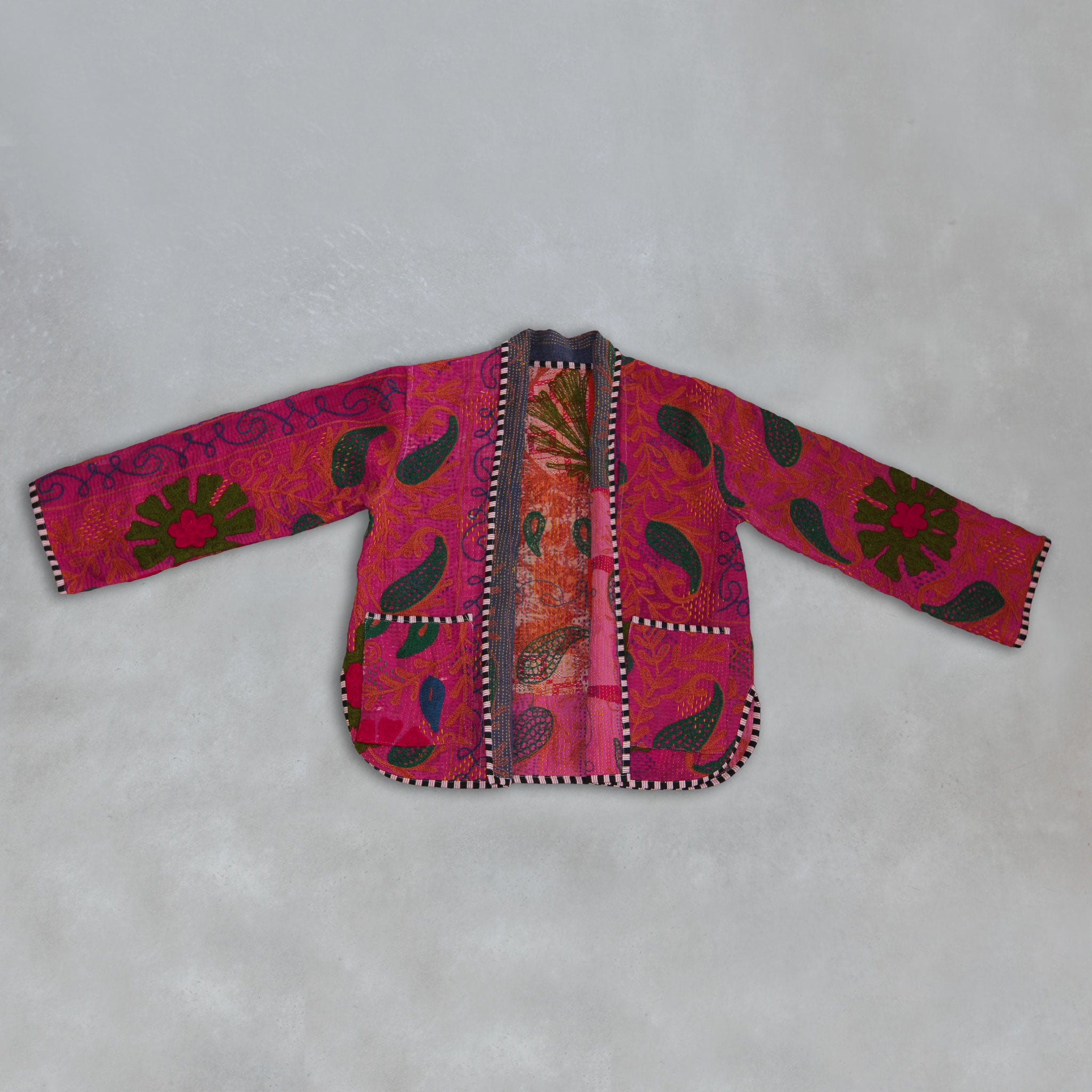 Colourful pink Kantha embroidered jacket on a grey background