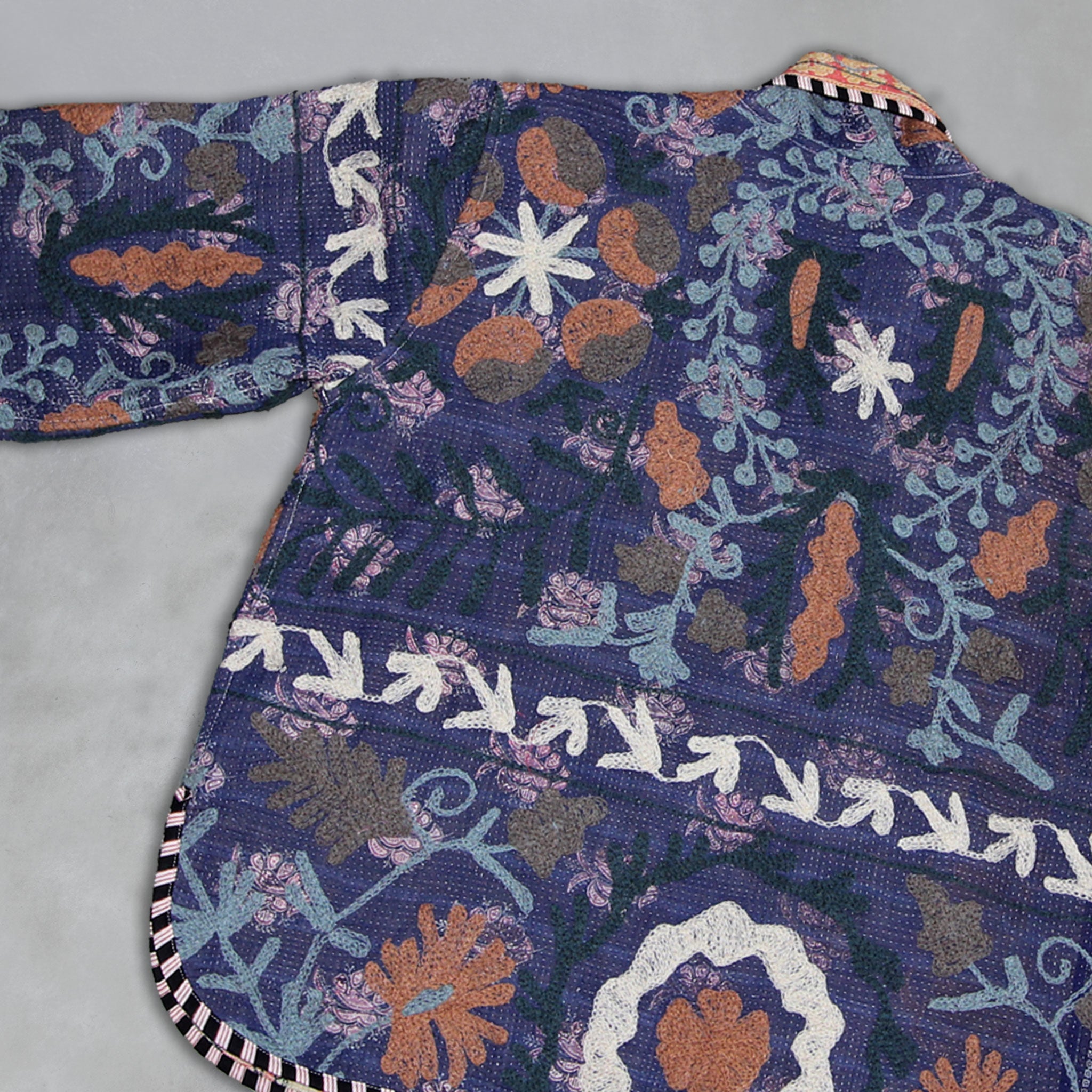 Colourful embroidered Kantha jacket with intricate patterns on a grey background